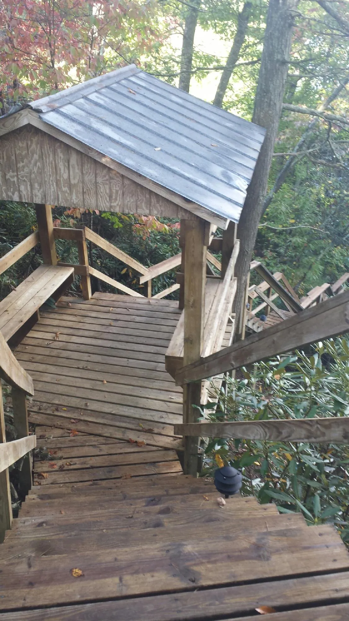 Metal roofed shelter over wooden steps on a wooded walkway — Skylight Repair & Installation work by our crew in Leominster