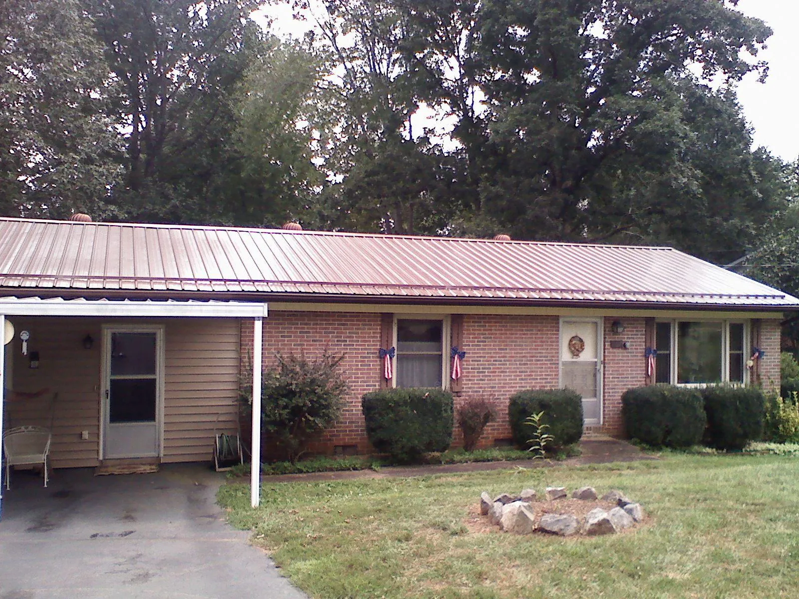 Bronze metal roof and carport on a brick ranch home — Roof Repair work by our crew in Leominster